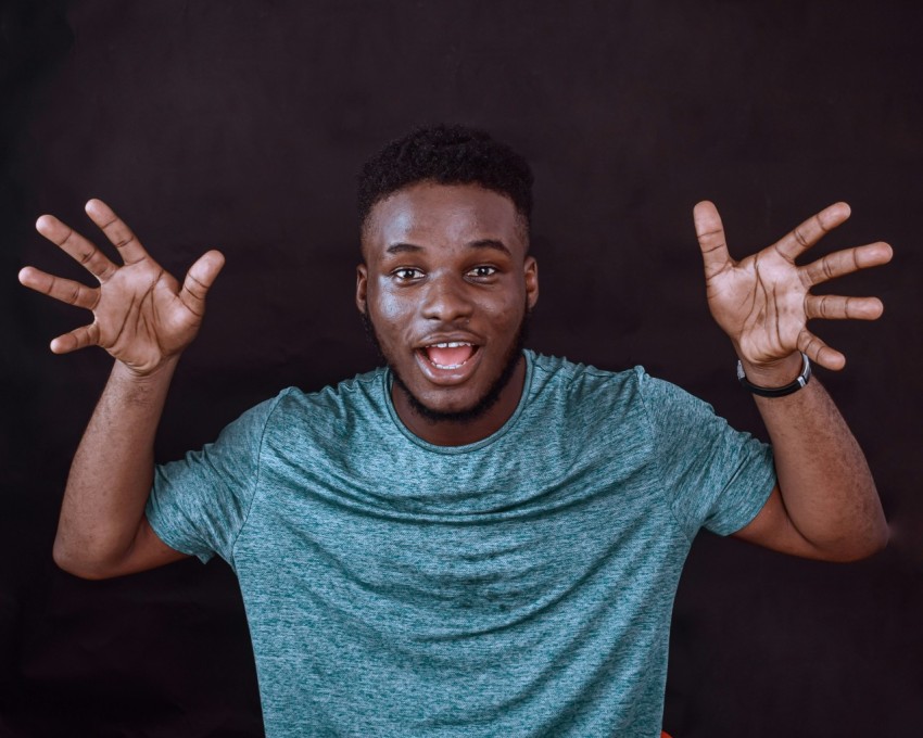 man in green crew neck t shirt making peace sign