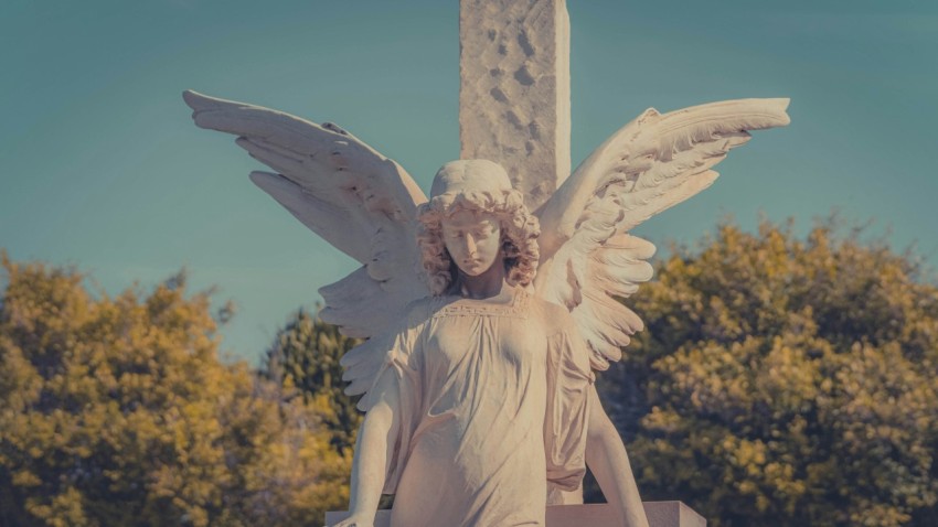 a statue of an angel holding a cross XS5W