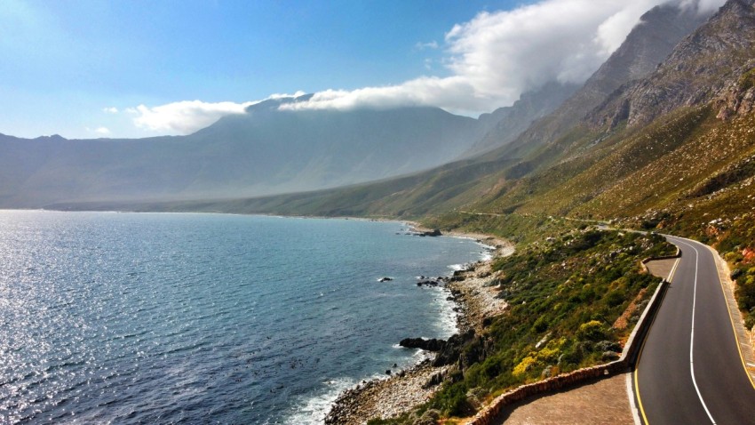 a scenic view of a road next to a body of water