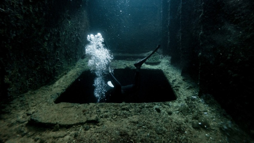a scuba diver in a deep underwater tunnel