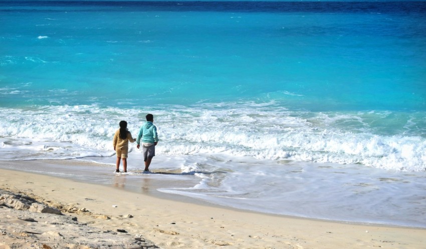 a man and a woman walking on the beach