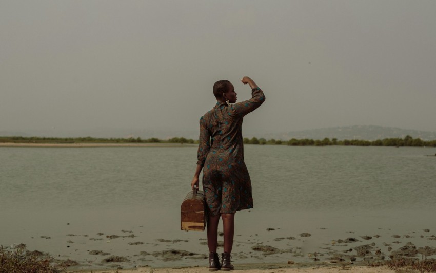a person standing on a beach with a suitcase