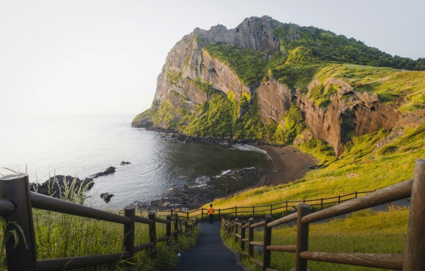 a path leading to a beach with a mountain in the background LDPgm6Aid