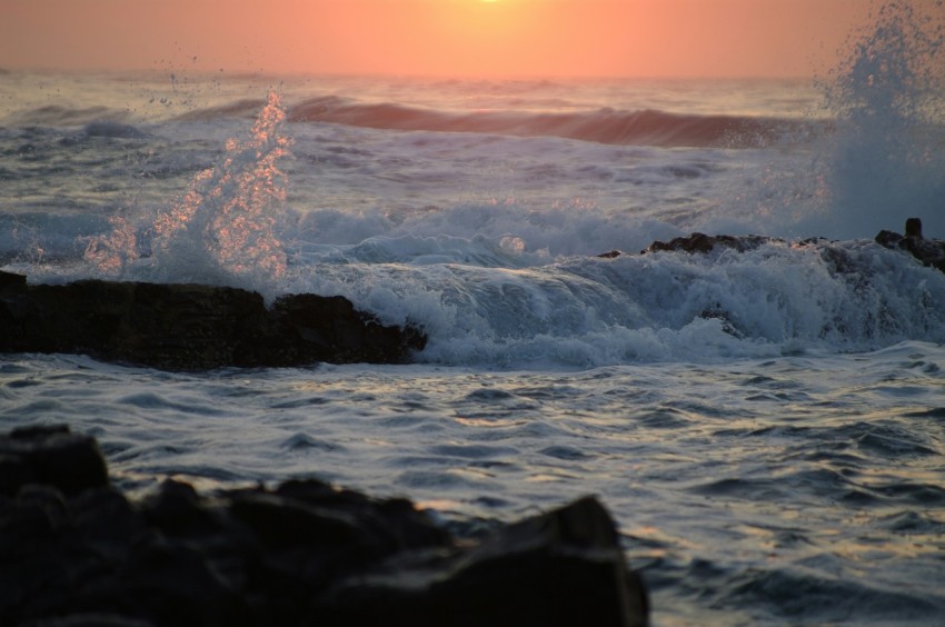 the sun is setting over the ocean waves