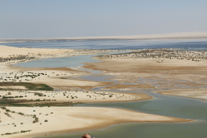 a man flying a kite over a sandy beach
