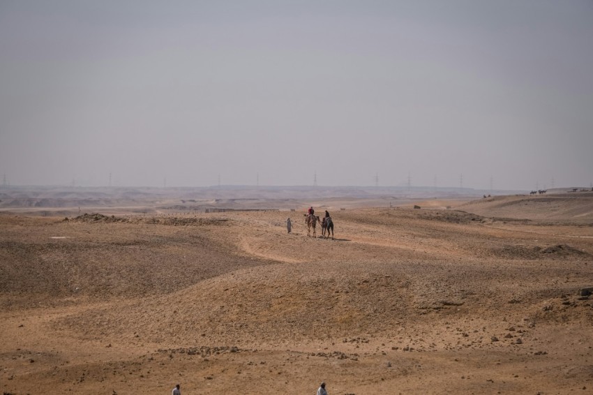 a group of people riding horses in a desert