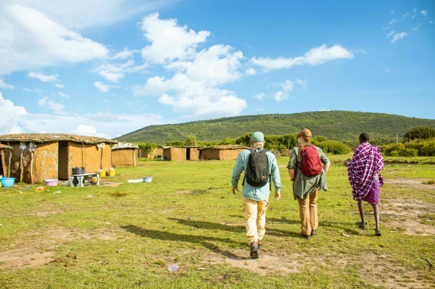 a couple of people that are walking in the grass