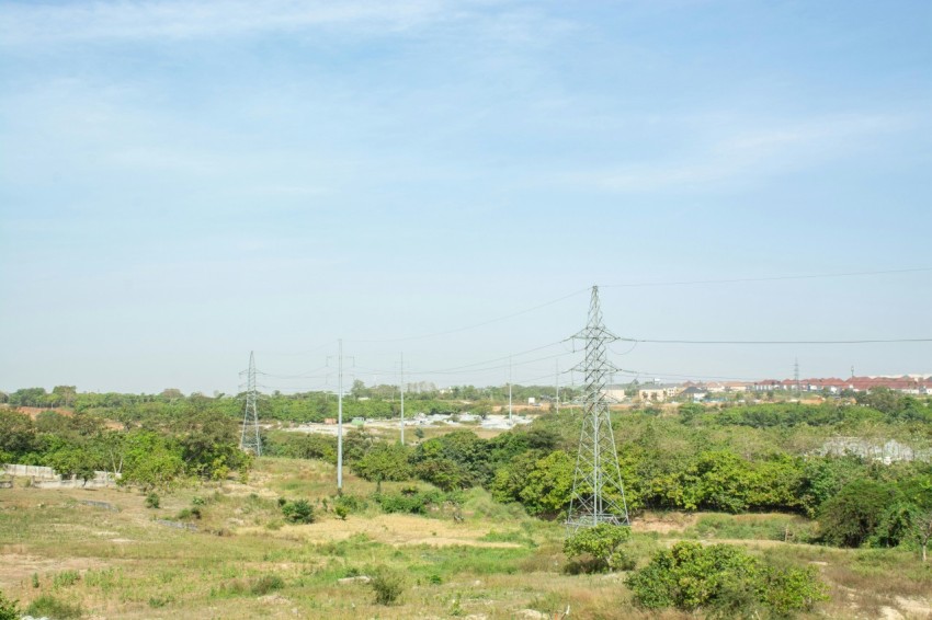 a grassy field with power lines in the distance