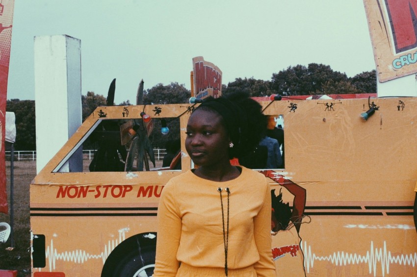 woman in yellow turtleneck sweater standing near brown building during daytime eYNqxAuM4