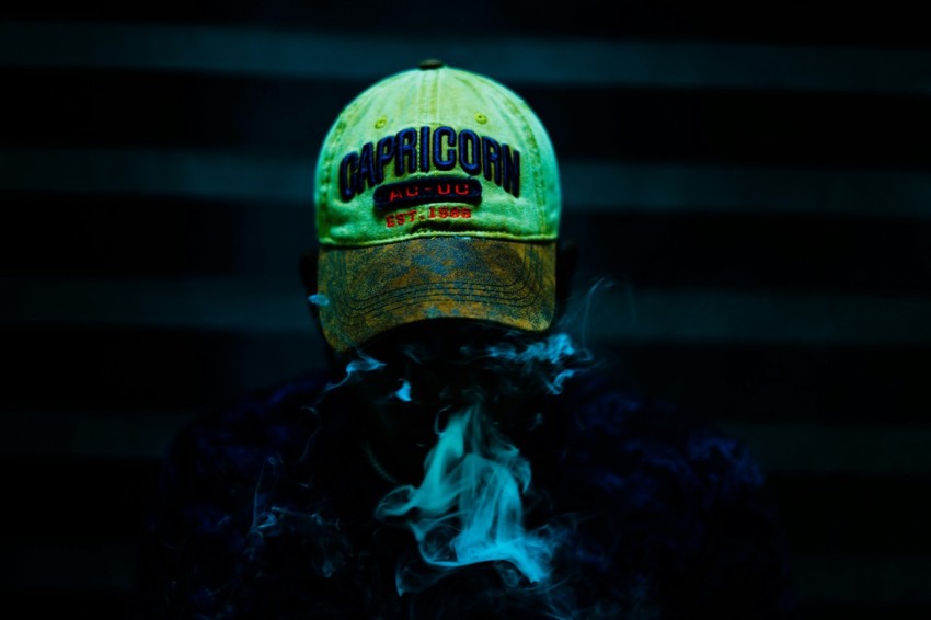 a person wearing a yellow hat with a green cap on top of it