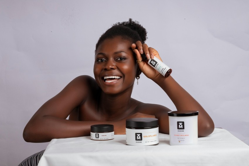 a woman sitting at a table with some skin care products
