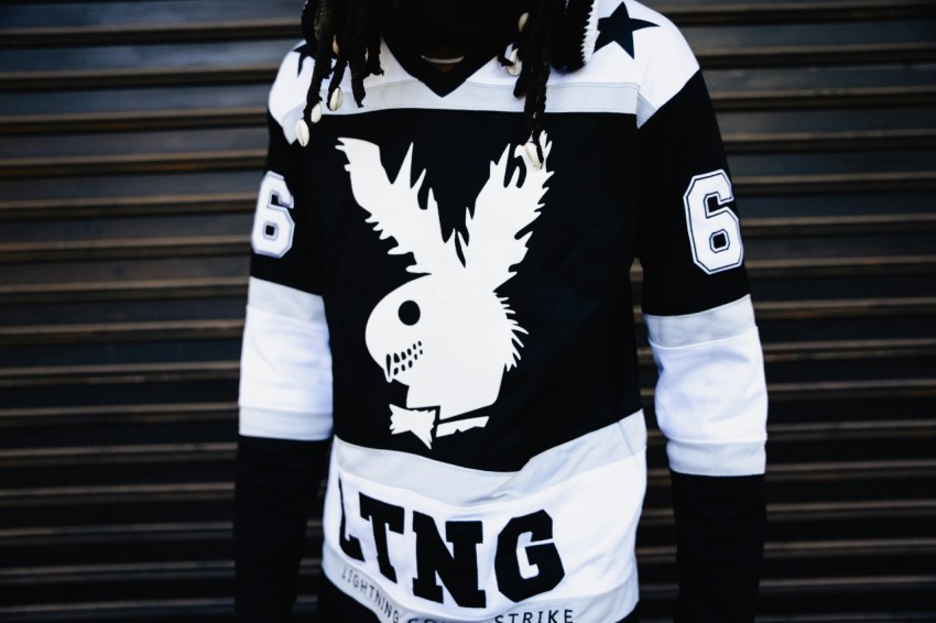 a man with dreadlocks wearing a black and white jersey 82Z4tvr