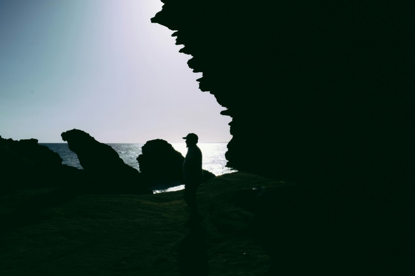 a person standing on a beach next to the ocean 611Eu4