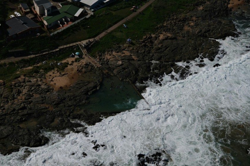 an aerial view of the ocean with houses in the background 5I1P0