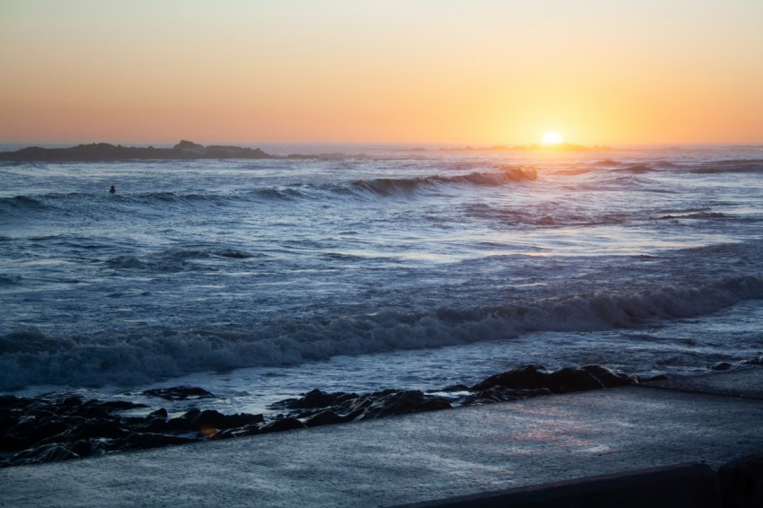 the sun is setting over the ocean waves n