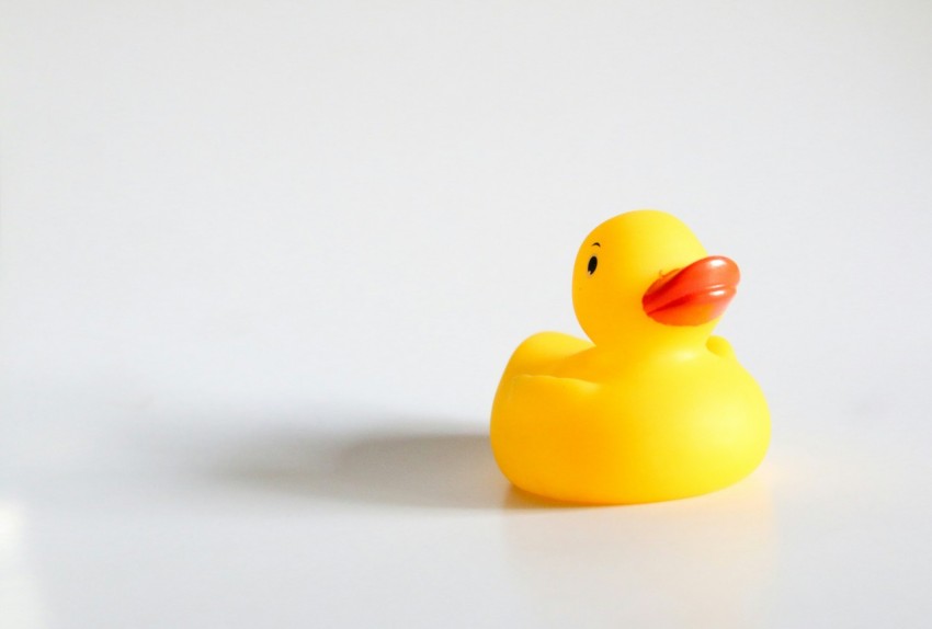a yellow rubber duck sitting on top of a white table