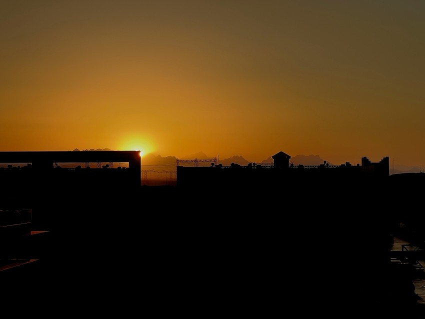 the sun is setting over a city skyline