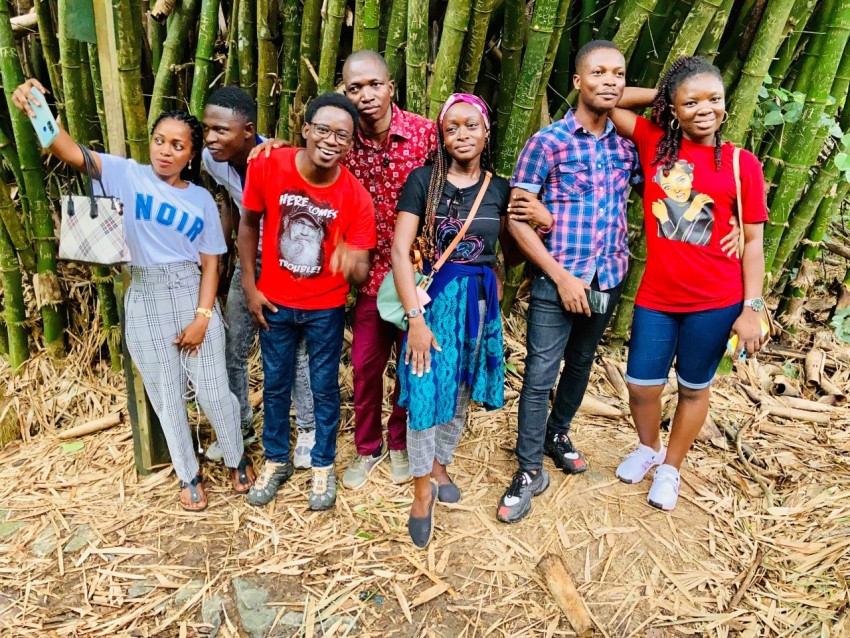 a group of people standing in front of a bamboo tree