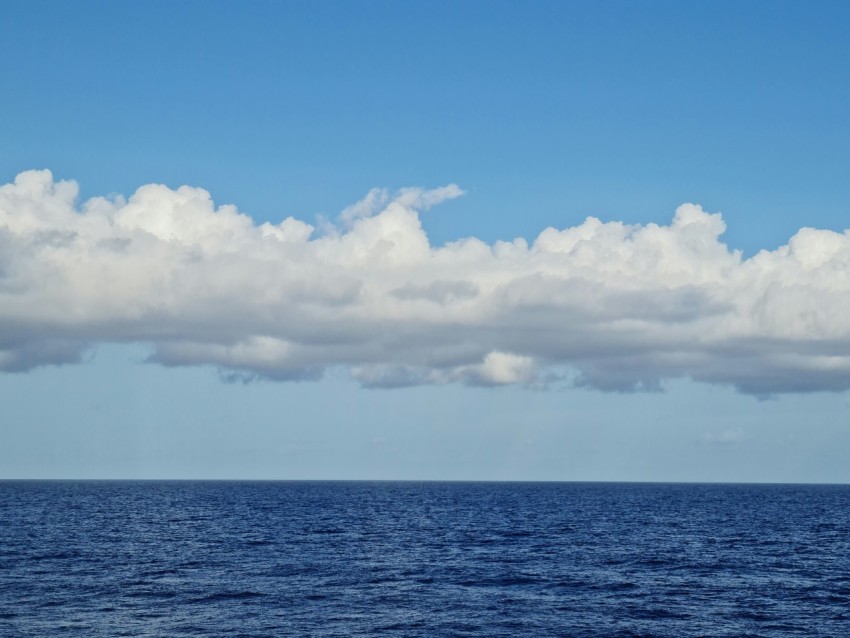 blue ocean under white clouds and blue sky during daytime OPRiEK4