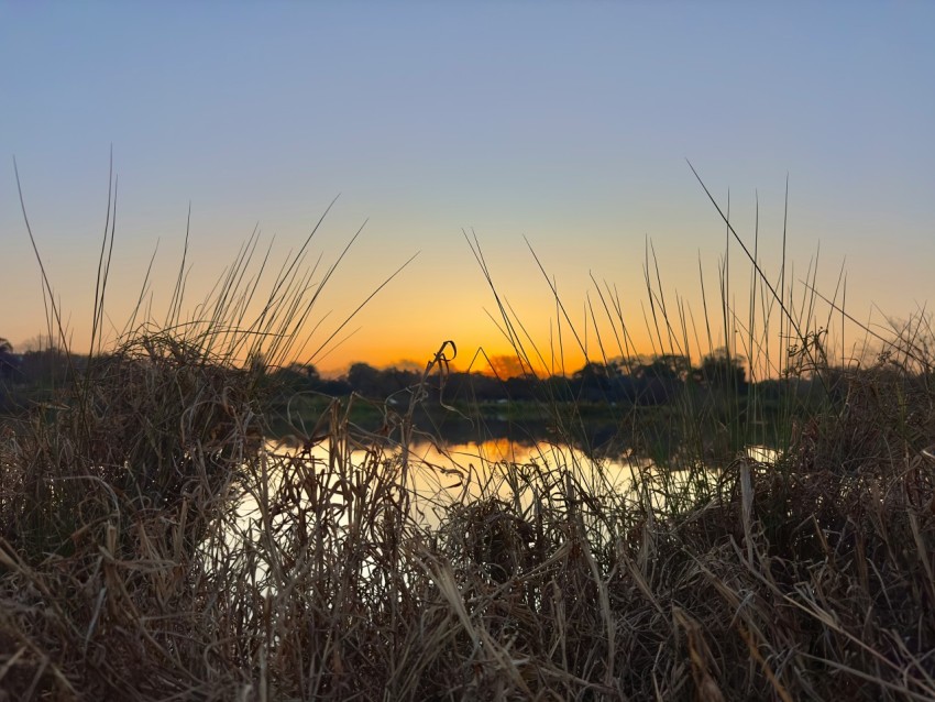 the sun is setting over a body of water nuAK