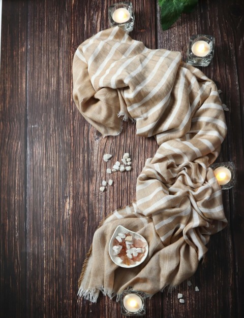 a wooden table topped with candles and a scarf