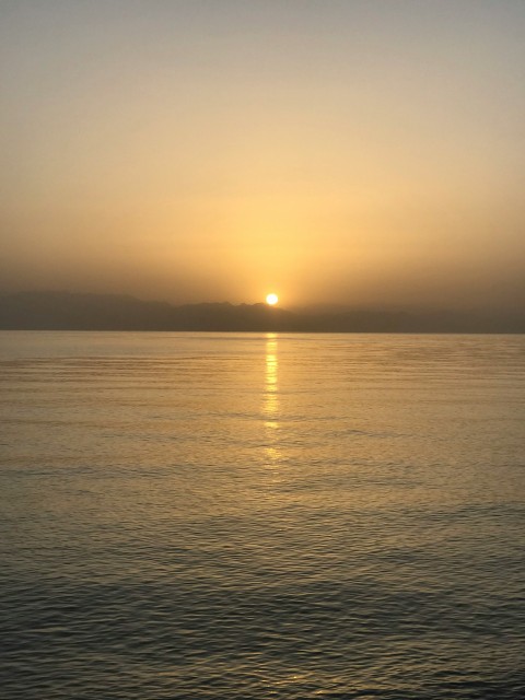 the sun is setting over the water in the ocean