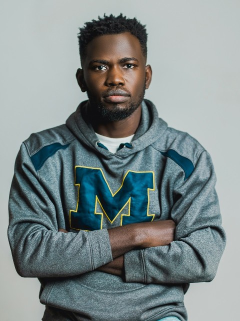 a man with his arms crossed posing for a picture