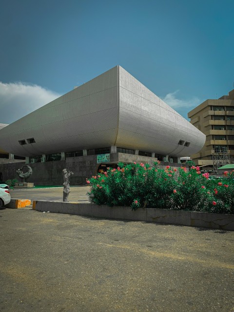 a building with a large triangular roof next to a parking lot