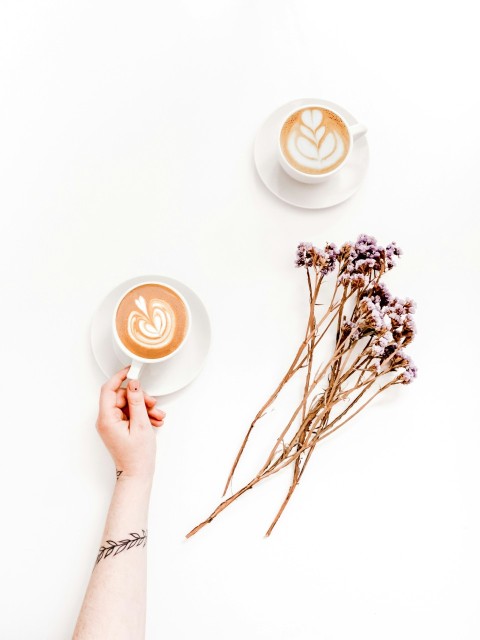 two cups near pink flowers