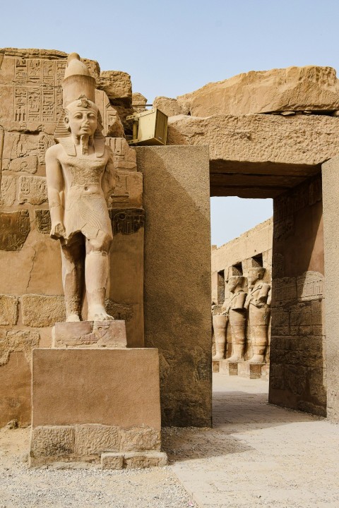 a statue of an egyptian god in front of a doorway