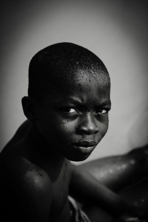 a black and white photo of a boy with no shirt