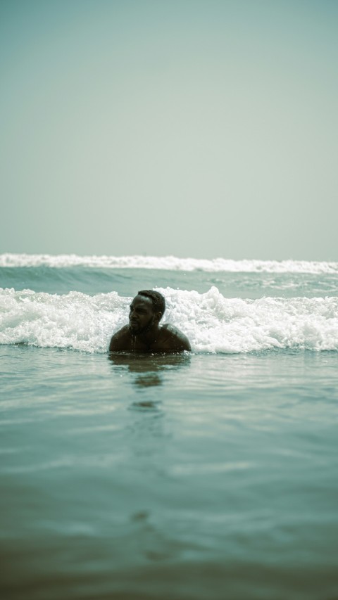 a man swimming in the ocean with his head in the water