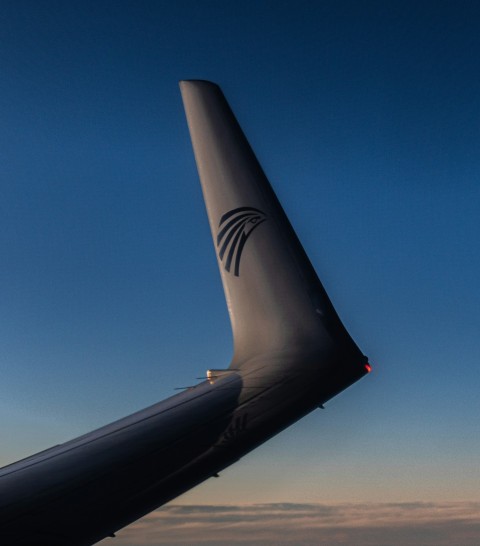 the tail end of an airplane against a blue sky